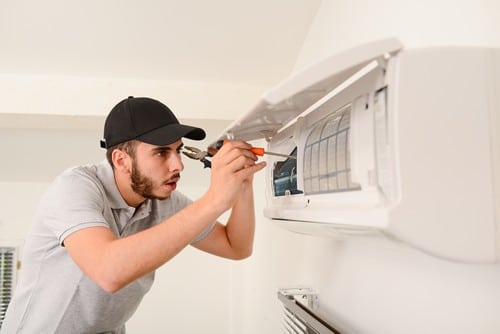 électricien Le Puy-en-Velay - Un électricien répare un climatiseur