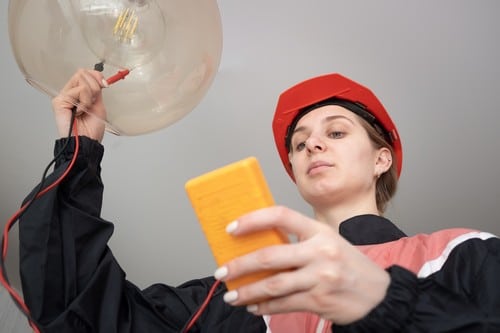 électricien Limeil-Brévannes - Un électricien installe une lampe au plafond