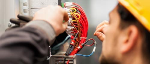 électricien Longjumeau - Un électricien répare un tableau électrique