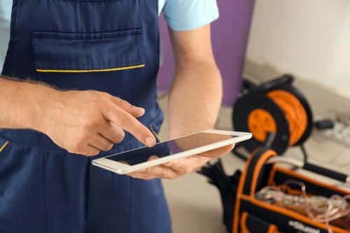 électrcien-Montigny-le-Bretonneux-les bons artisan-électricien avec une tablette