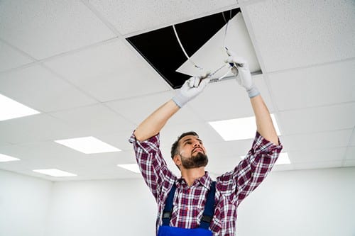 électricien Plaisir - Un artisan électricien fait passer l'électricité dans le plafond