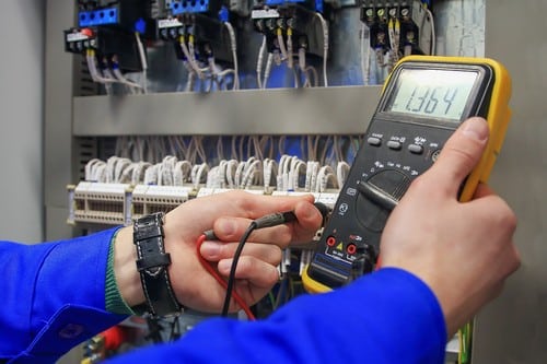 électricien Poissy - un artisan utilise un multimètre pour mesurer le courant