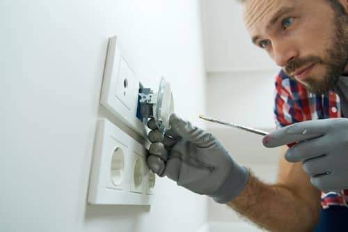 électricien Saint-Dizier - les bons artisans - électricien qui répare une prise électrique