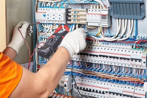 électricien Savigny-sur-Orge - un artisan inspecte un tableau électrique avec son multimètre