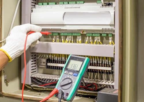 électricien Sedan - Un électricien contrôle un tableau électrique