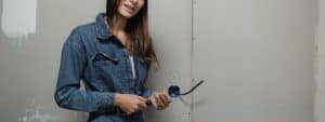 électricien Verdun - Une électricienne répare une prise électrique