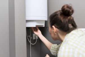 Une femme inspecte son cumulus électrique