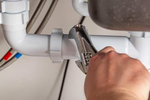 plombier Sceaux - Un plombier répare un tuyau