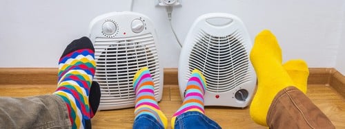 Chauffagiste Paris 15ème - les bons artisans - famille qui se réchauffe les pieds près d'un radiateur