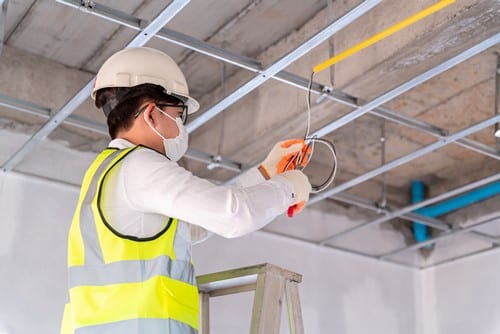 Électricien Lyon 9 - les bons artisans - Electricien qui coupe des fils sur un chantier