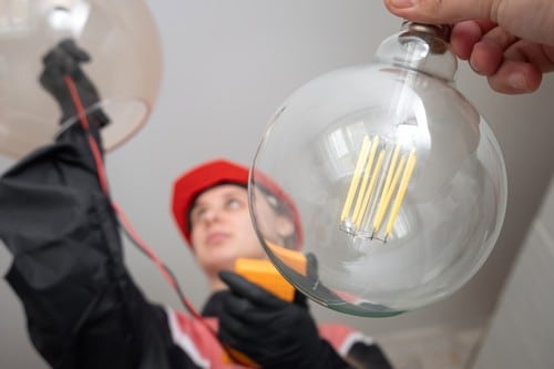 Electricien Paris 4 - les bons artisans - électricien qui installe une ampoule