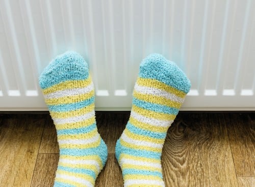 chauffagiste Leers - Se réchauffer les pieds devant un radiateur