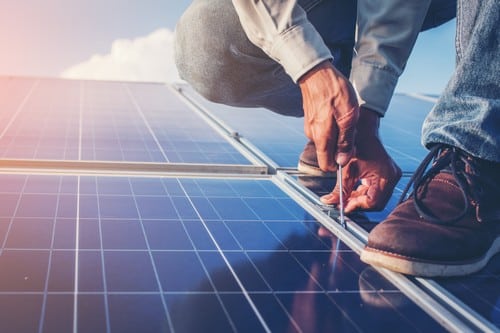 Electricien Allennes-les-Marais - mains d'un homme qui règle un panneau solaire