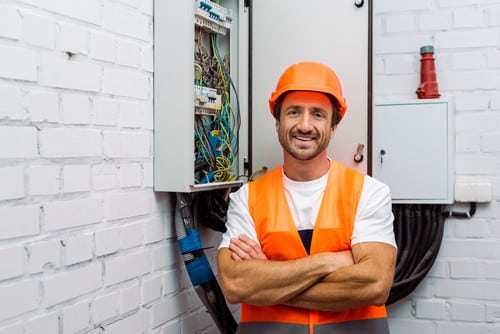 Electricien Allennes-les-Marais - homme qui sourit devant un tableau électrique