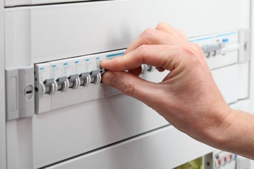 electricien Carry-le-Rouet - main d'un homme qui règle les bouton d'un tableau électrique