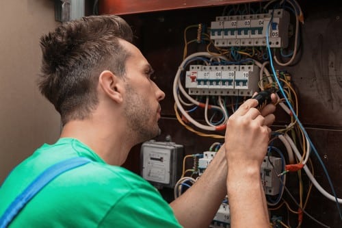 Electricien Davron - homme devant un tableau électrique