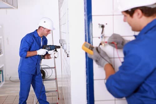 Electricien La Mulatière - deux hommes qui règles des tuyaux électriques