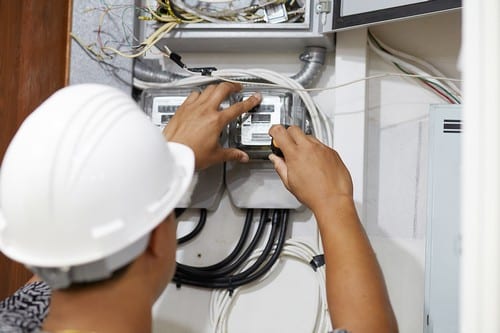 Electricien Louveciennes - homme avec un casque qui règle un outil électrique