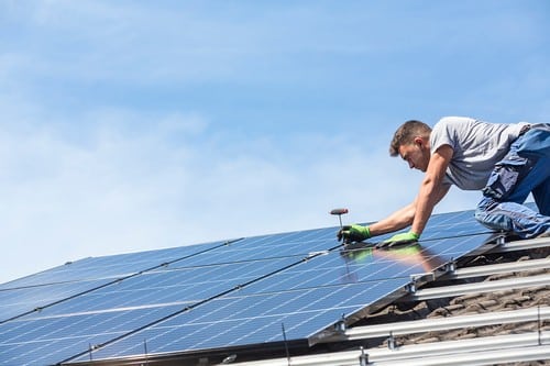 Electricien Saint-Forget - homme sur un toit qui installe des panneaux solaires