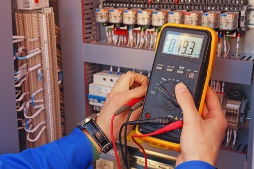 Electricien Chavenay - mains d'un homme avec un appareil électrique