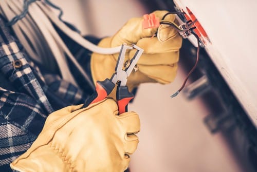 électricien le vesinet - mains d'un homme qui règle un câble électrique