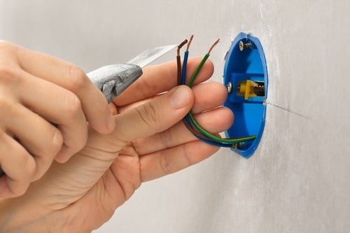 Electricien Mimet - mains d'un homme qui règle des câbles électriques