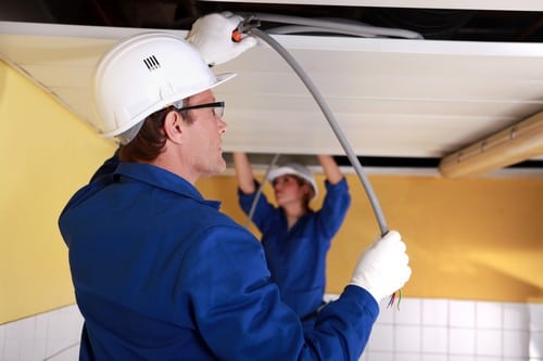 Electricien Peypin - homme qui répare un plafond avec câbles électriques