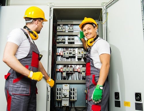 Electricien Yvrac - deux hommes qui réparent un tableau électrique