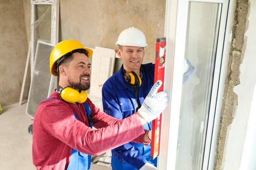 Vitrier Mimet - deux hommes sur un chantier qui installent une fenêtre