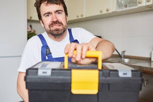 Plombier Courcouronnes - homme qui tient une caisse à outils