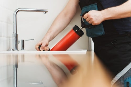 Plombier Dourdan - mains d'un homme qui débouche un évier