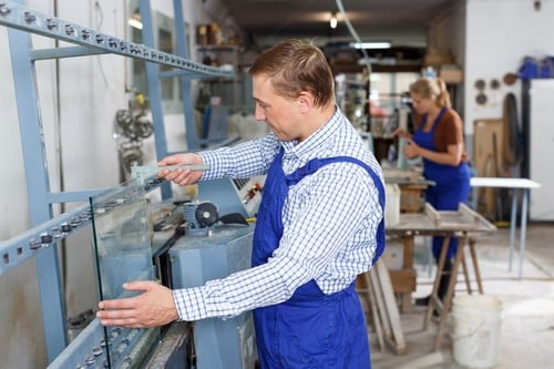 Vitrier Rennemoulin - deux personnes dans une usine qui fabrique des fenêtres