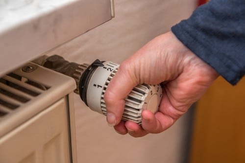 chauffagiste Bry-sur-Marne - un homme utilise la vanne thermostatique d'un radiateur