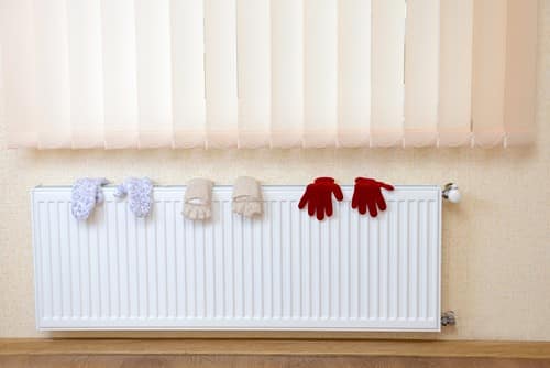 chauffagiste Fontainebleau - un radiateur avec des gants