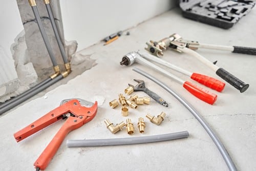 chauffagiste Verrières-le-Buisson - un ensemble d'outils posés sur le sol d'une maison en rénovation