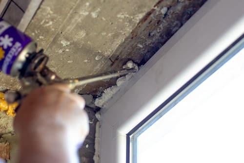 Vitrier Avelin - mains d'un homme qui analyse un mur en haut d'une fenêtre