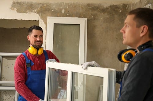 Vitrier Lesquin- deux hommes qui portent une fenêtre pour l'installer