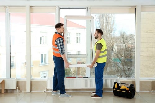 Vitrier Lezennes - deux hommes qui installent une fenêtre dans une grande pièce