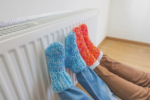 Chauffagiste Apt - pieds avec chaussettes posés sur un chauffage