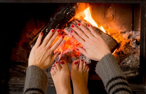 Chauffagiste Château-Gontier - mains et pieds qui se réchauffent près du feu