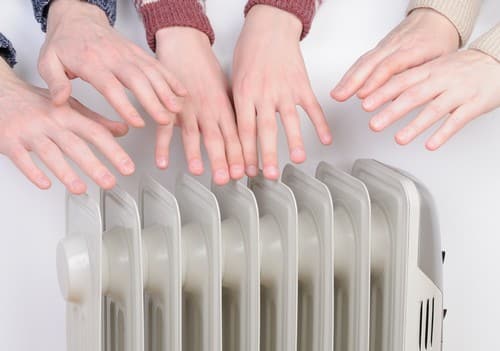 Chauffagiste Cuers - mains qui se réchauffent au dessus du chauffage