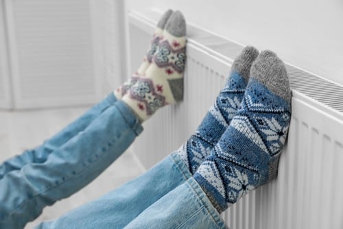 Chauffagiste Dinard - les bons artisans - pieds contre un radiateur