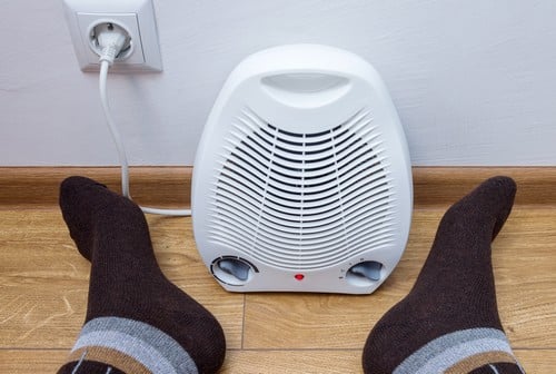 Chauffagiste Fameck - les bons artisans - pieds qui se réchauffent près d'un radiateur électrique