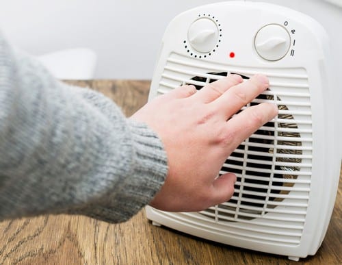 Chauffagiste Guipavas - les bons artisans - mains qui se réchauffe avec un radiateur électrique