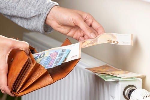 Chauffagiste Luçon - mains qui posent des billets sur un chauffage