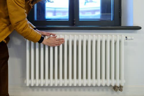 Chauffagiste Ostwald - les bons artisans - mains contre un radiateur pour se réchauffer