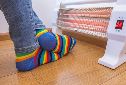 Chauffagiste Ploemeur - les bons artisans - pieds qui se réchauffent devant un radiateur électrique