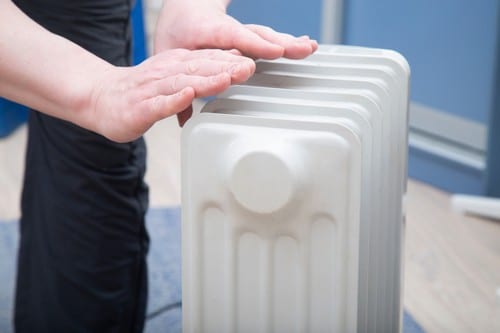 Chauffagiste Portet-sur-Garonne - les bons artisans - mains sur un radiateur