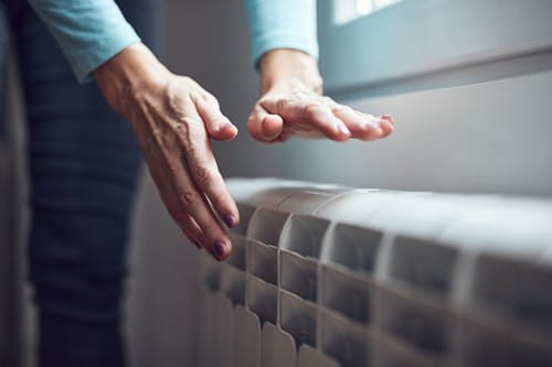 Chauffagiste Saint-Gilles - les bons artisans - mains au dessus d'un radiateur