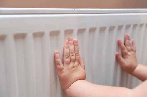 Chauffagiste Saint-Hilaire-de-Riez - mains d'un enfant posées sur un chauffage